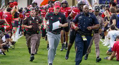 Dec 23, 2025; Boca Raton, FL, USA; Louisville Cardinals head coach Jeff Brohm leads his team on the field before the Boca Raton Bowl at Flagler CU Stadium. Mandatory Credit: Jeff Romance-Imagn Images