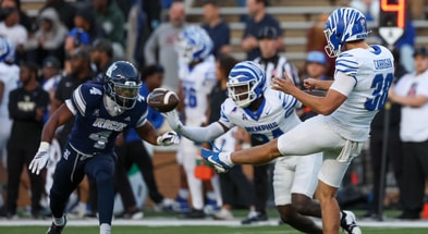 Memphis Tigers punter Lachlan Carrigan (30) is rushed by Rice Owls special teams Marcus Williams (4) in the first quarter at Rice Stadium
