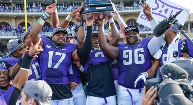 TCU Horned Frogs quarterback Trevone Boykin (2) and safety Sam Carter (17) and defensive tackle Chucky Hunter (96) hold up the Big 12 championship trophy after the game against the Iowa State Cyclones at Amon G. Carter Stadium