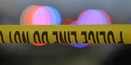 Police tape is strung up with police sirens flashing in the background - © John Oliva/Caller-Times / USA TODAY NETWORK