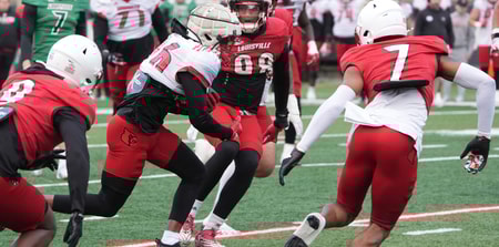 Louisville Duke Watson (26) catches the ball and ran from some yardage against Red Louisville Rodney Johnson (7) in the Spring Game Friday night at L & N Stadium. April 11, 2025