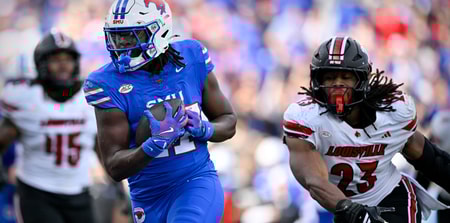 Nov 22, 2025; Dallas, Texas, USA; SMU Mustangs running back T.J. Harden (27) eludes the tackle of Louisville Cardinals defensive lineman Wesley Bailey (23) for a touchdown during the first half at Gerald J. Ford Stadium. Mandatory Credit: Jerome Miron-Imagn Images