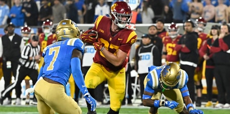 USC Trojans tight end Lake McRee (87) runs a pass between UCLA Bruins defensive back K.J. Wallace (7) and defensive back Bryan Addison (4) during the second quarter at Rose Bowl