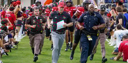 Dec 23, 2025; Boca Raton, FL, USA; Louisville Cardinals head coach Jeff Brohm leads his team on the field before the Boca Raton Bowl at Flagler CU Stadium. Mandatory Credit: Jeff Romance-Imagn Images