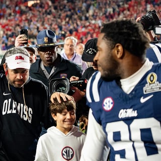 Ole Miss Head Coach Pete Golding raises a fist as he leaves the field after winning the first round of the College Football