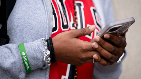 A Tennessee student uses a cell phone before putting it in a Yondr pouch during the school day, via Denny Simmons : The Tennessean : USA TODAY NETWORK via Imagn Images