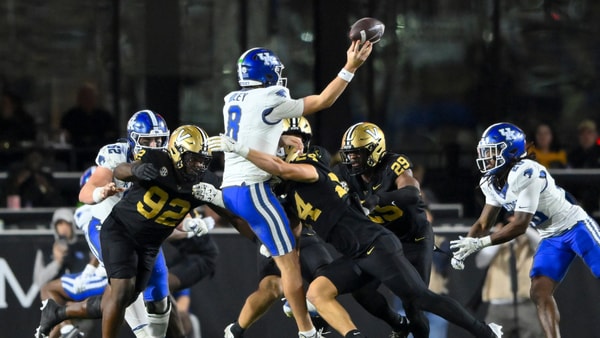 Nov 22, 2025; Nashville, Tennessee, USA; Kentucky Wildcats quarterback Cutter Boley (8) gets hit as he release the ball by Vanderbilt Commodores defensive lineman Jaylon Stone (92) and linebacker Nick Rinaldi (24) during the second half at FirstBank Stadium. Mandatory Credit: Steve Roberts-Imagn Images