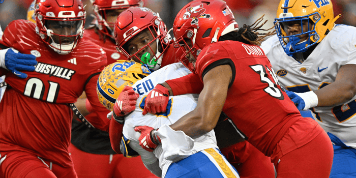 Nov 23, 2024; Louisville, Kentucky, USA; Louisville Cardinals linebacker Stanquan Clark (6) and linebacker TJ Quinn (34) tackle Pittsburgh Panthers running back Desmond Reid (0) during the first half at L&N Federal Credit Union Stadium. Mandatory Credit: Jamie Rhodes-Imagn Images