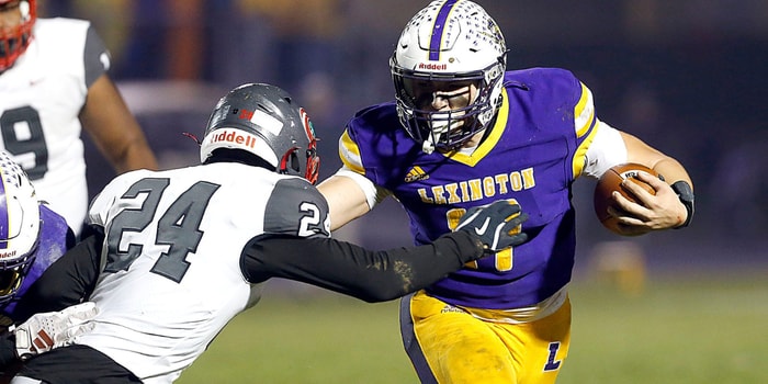 Lexington High School QB and Michigan State signee Joe Caudill (17) eludes a tackle by Toledo Central Catholic High School's Jason Lawson Jr. (24) during OHSAA Division III regional quarterfinal high school football action. - Tom E. Puskar, USA TODAY Sports
