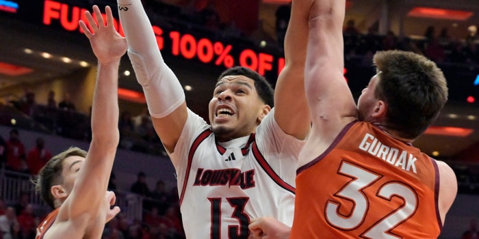 Jan 24, 2026; Louisville, Kentucky, USA; Louisville Cardinals forward Sananda Fru (13) shoots against Virginia Tech Hokies center Christian Gurdak (32) and Virginia Tech Hokies guard Neoklis Avdalas (17) during the first half at KFC Yum! Center. Mandatory Credit: Jamie Rhodes-Imagn Images
