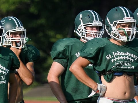 Head coach Rich Alercio and some members of the St. Johnsbury Academy football team watch the action during the scrimmage at