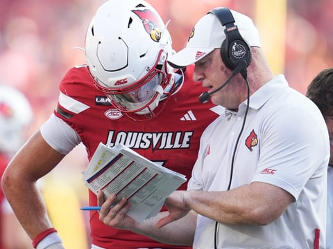 Louisville Cardinals head coach Jeff Brohm talks with Louisville Cardinals quarterback Lincoln Kienholz (3) in the second half