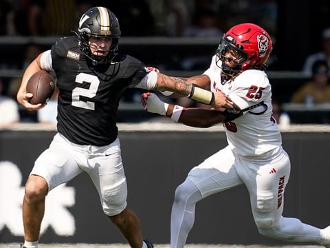 Vanderbilt quarterback Jared Curtis (2) evades NC State linebacker Sterling Dixon (25) during the fourth quarter at FirstBank