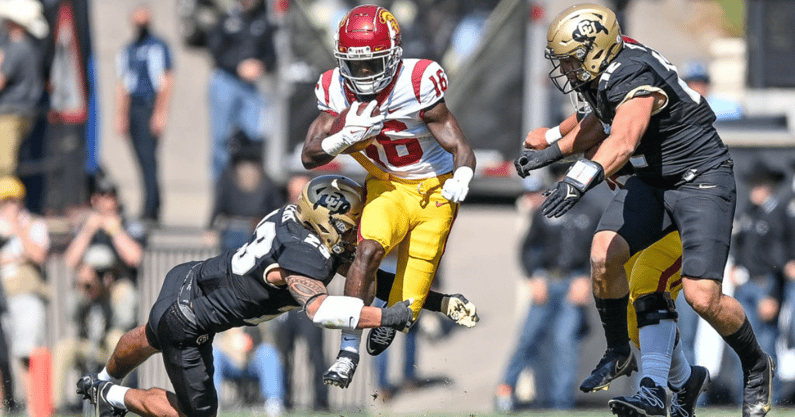 Wide receiver Tahj Washington #16 of the USC Trojans is hit by safety Isaiah Lewis #23 of the Colorado Buffaloes in the first quarter of a game at Folsom Field on October 2, 2021 in Boulder, Colorado. (Photo by Dustin Bradford/Getty Images)