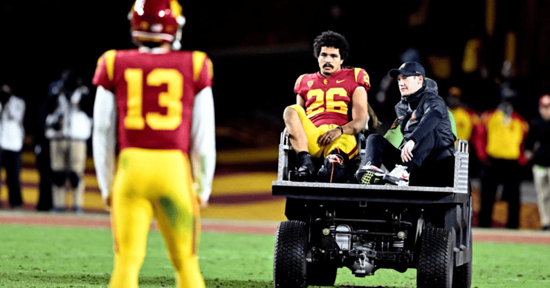 Quarterback Caleb Williams #13 of the USC Trojans looks at running back Travis Dye #26 of the USC Trojans as he is carted off the field after an injury against the Colorado Buffaloes in the first half of a NCAA football game at the Los Angeles Memorial Co