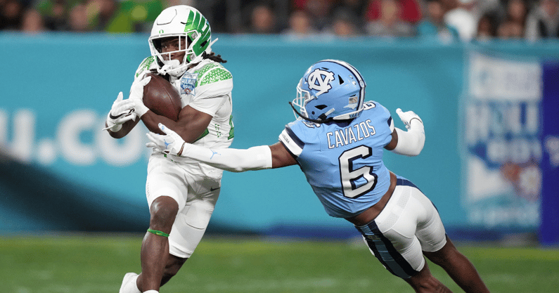 Oregon Ducks running back Noah Whittington (22) carries the ball against Michigan State and former North Carolina Tar Heels defensive back Lejond Cavazos (6) during the first half of the 2022 Holiday Bowl at Petco Park. - Kirby Lee, USA TODAY Sports