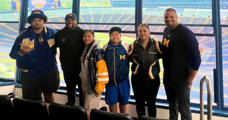 Douglas Utu and family with Michigan coaching staff (Ane Utu/X)