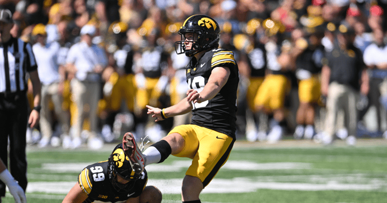 Aug 31, 2024; Iowa City, Iowa, USA; Iowa Hawkeyes place kicker Drew Stevens (18) kicks an extra point as punter Ty Nissen (99) holds during the fourth quarter against the Illinois State Redbirds at Kinnick Stadium. Mandatory Credit: Jeffrey Becker-Imagn Images