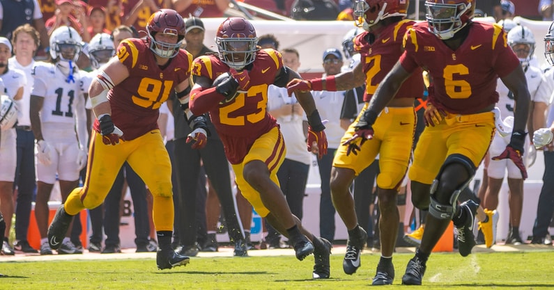 USC linebacker Desman Stephens returns an interception behind blocking from his teammates during a game against Penn State