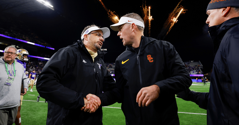 Washington Huskies head coach Jedd Fisch, left, shakes hands with USC Trojans head coach Lincoln Riley following a Washington victory at Alaska Airlines Field at Husky Stadium