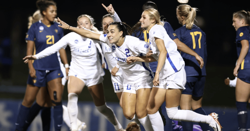Maddie Kemp celebrates with her teammates after scoring a goal - UK Athletics