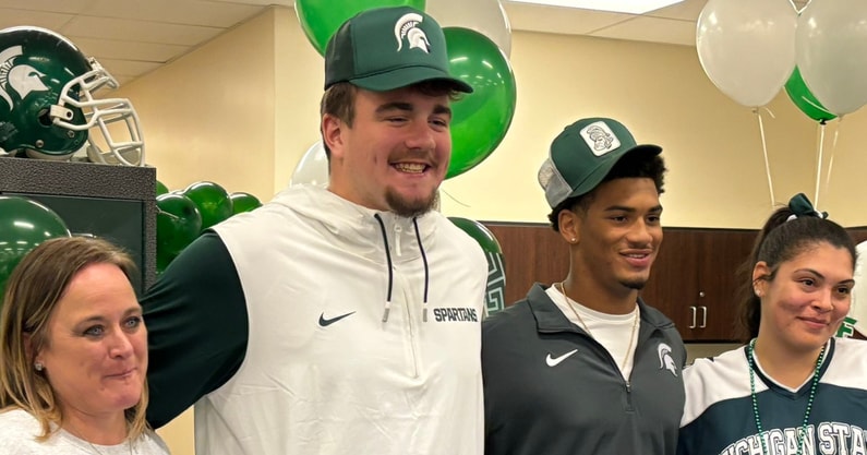 Michigan State signees Justin Bell and DiMari Malone celebrate with their mothers at Macomb Dakota's signing day on Wednesday (Photo by Kenny Jordan).