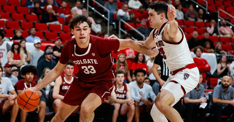 Nov 18, 2024; Raleigh, North Carolina, USA; Colgate Raiders forward Sam Wright (33) dribbles with the ball guarded by North Carolina State Wolfpack guard Michael O'Connell (12) during the second half of the game at Lenovo Center. Mandatory Credit: Jaylynn Nash-Imagn Images