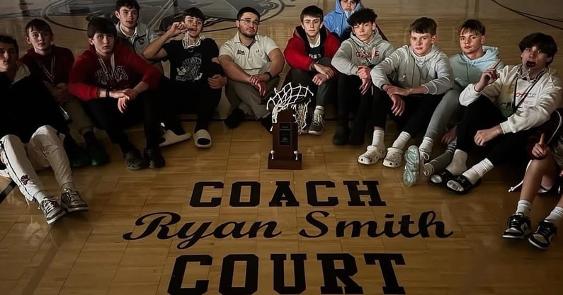 Team photo with trophy on home court. Dedicated to Coach Ryan Smith
