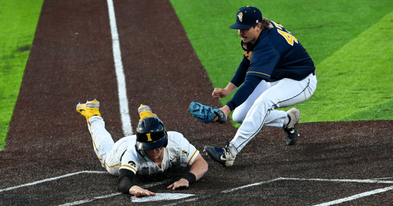 Iowa catcher Reese Moore scores on a wild pitch against Augustana College. (Photo by Dennis Scheidt)
