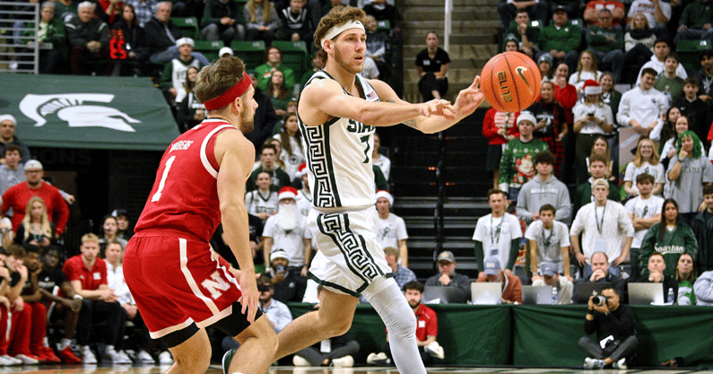 Michigan State Spartans guard Gehrig Normand (7) passes to a teammate in front of Nebraska Cornhuskers guard Sam Hoiberg (1) during the second half at Jack Breslin Student Events Center. - Dale Young, USA TODAY Sports