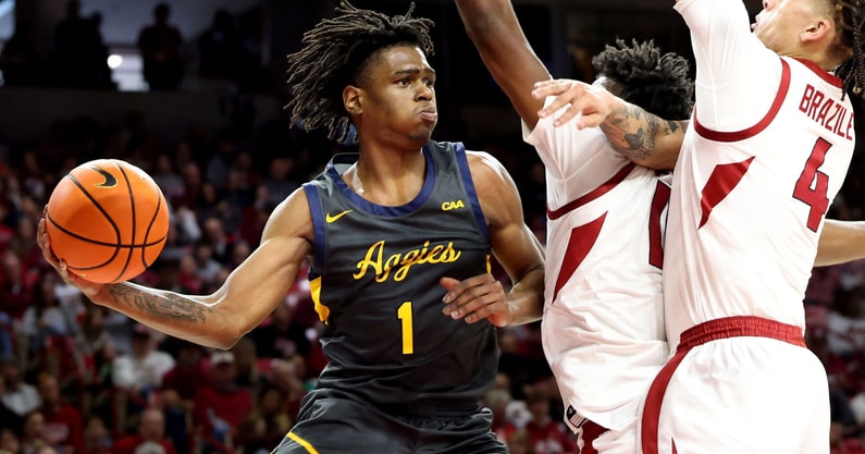 Dec 21, 2024; Fayetteville, Arkansas, USA; North Carolina A&T Aggies guard Ryan Forrest (1) passes in the first half as Arkansas Razorbacks forward Trevon Brazile (4) defends at Bud Walton Arena. Mandatory Credit: Nelson Chenault-Imagn Images