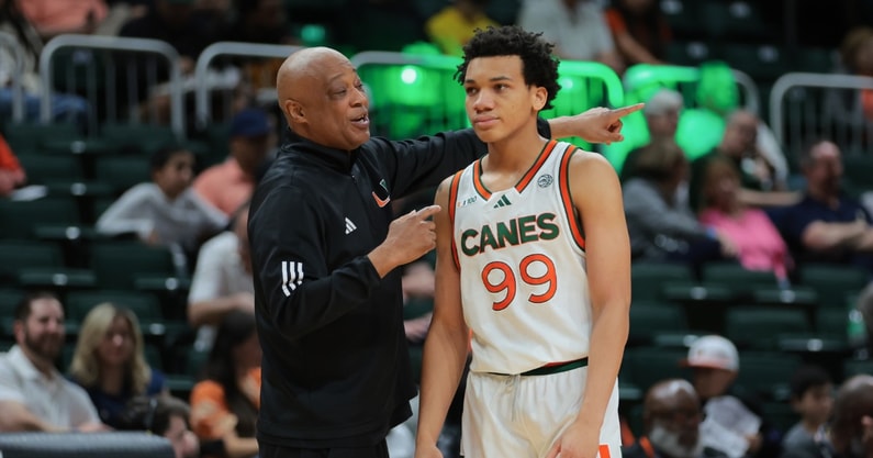 Feb 1, 2025; Coral Gables, Florida, USA; Miami Hurricanes interim head coach Bill Courtney talks to guard Divine Ugochukwu (99) during the first half against the Notre Dame Fighting Irish at Watsco Center. Mandatory Credit: Sam Navarro-Imagn Images
