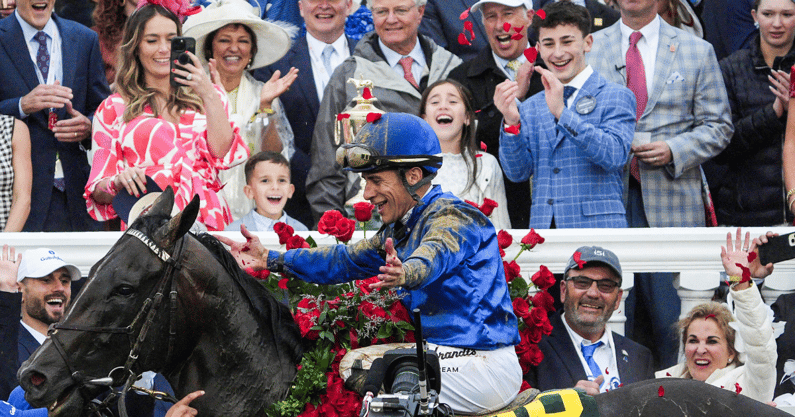 Kelly Alvarado captures the moment as her husband, jockey Junior Alvarado, tosses roses into the air in the Winner's Circle as their children celebrate behind him after he and Sovereignty won the 2025 Kentucky Derby Saturday, May 3, 2025 at Churchill Downs in Louisville, Kentucky.