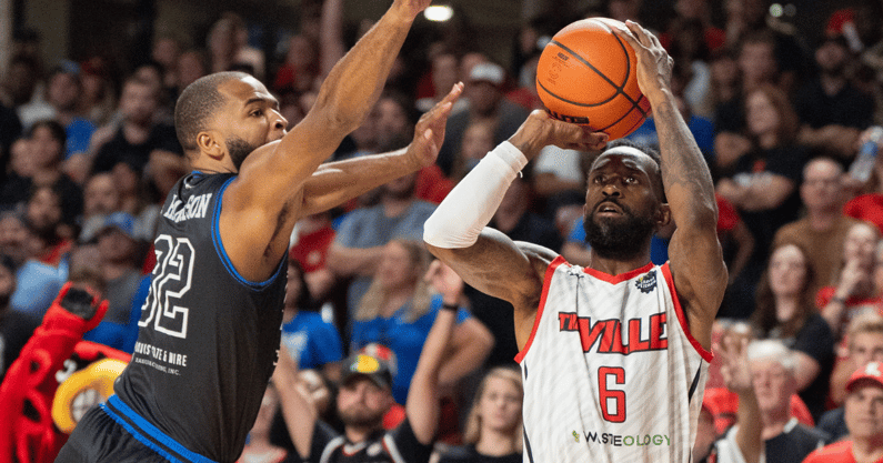 Aaron Harrison attempts to block a shot by Russ Smith in the TBT, via Clare Grant:Courier Journal : USA TODAY NETWORK