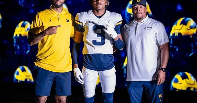 DB Andrew Clark with Michigan coaches Lamar Morgan and Lionel Stokes.