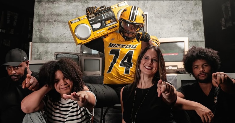 Braylon Ellison points to the camera with his family, including his father, Atiyyah Ellison, and brother, Tyson Ellison (Photo by Mizzou Football)