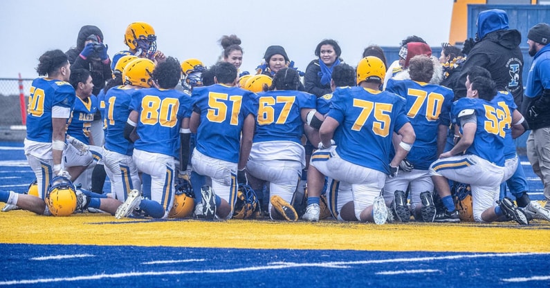 The Barrow Whalers huddles before an Alaska high school football game.