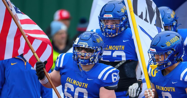 The Falmouth Navigators football team enter the field before a Maine high school football game.