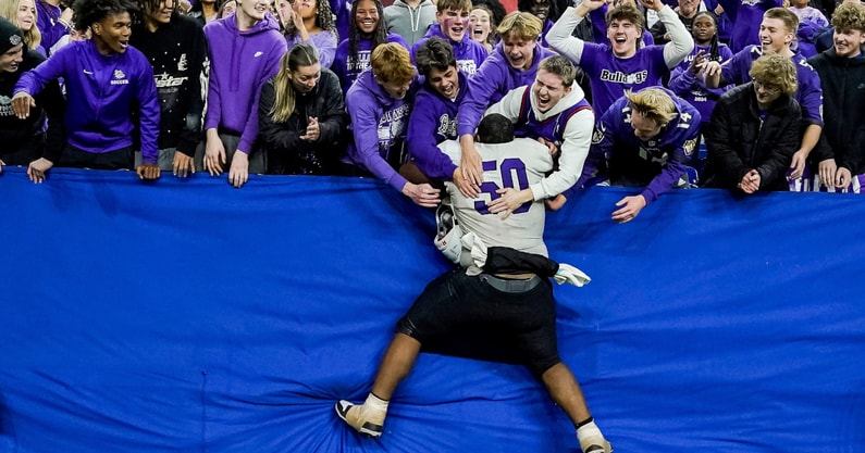 Brownsburg Bulldogs football player leaps into the stands after an Indiana high school football game.