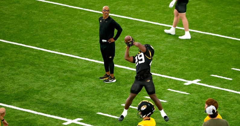 Missouri running backs coach Curtis Luper (back) watches running back Ahmad Hardy (29) catch a pass during fall camp