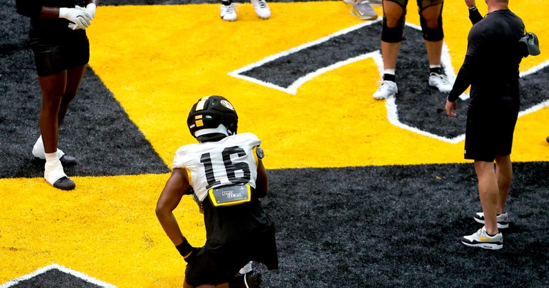 Javion Hilson (16) gets coached by Missouri DEs coach Brian Early (right) during a drill