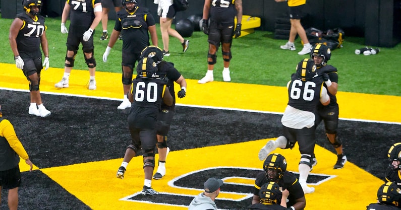 Johnny Williams (60) and Logan Reichert (66) go through warm up blocking drills