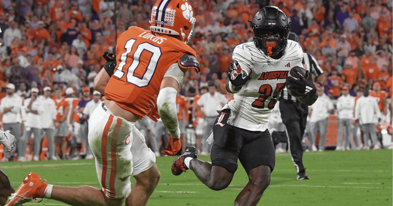 Nov 2, 2024; Clemson, South Carolina, USA; Louisville Cardinals running back Isaac Brown (25) runs the ball against Clemson Tigers cornerback Jeadyn Lukus (10) during the second quarter at Memorial Stadium. Mandatory Credit: Ken Ruinard-Imagn Images