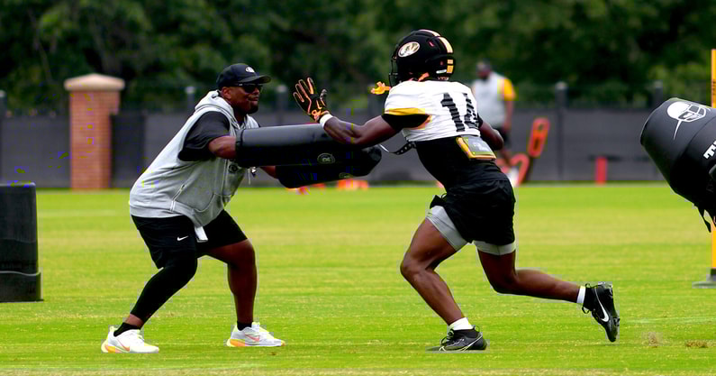 Triston Newson slaps by a pad held by linebackers coach Derek Nicholson