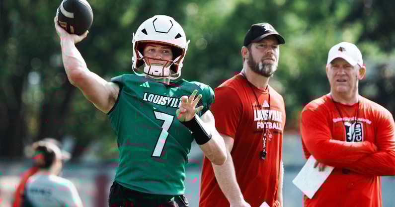 U of L QB Miller Moss (7) passes during practice as OC Brian Brohm and head coach Jeff Brohm, right, watch on the practice field at Cardinal Stadium in Louisville, Ky. on July 30, 2025.