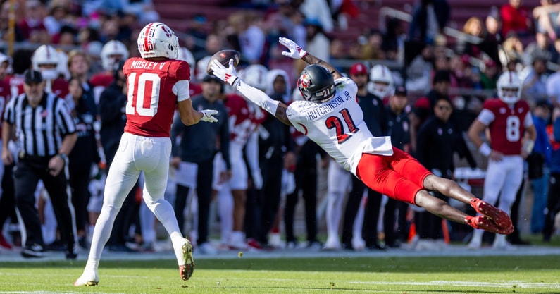 Nov 16, 2024; Stanford, California, USA; Louisville Cardinals defensive back D'Angelo Hutchinson (21) attempts to deflect a pass to Stanford Cardinal wide receiver Emmett Mosley V (10) during the first quarter at Stanford Stadium. Mandatory Credit: Bob Kupbens-Imagn Images