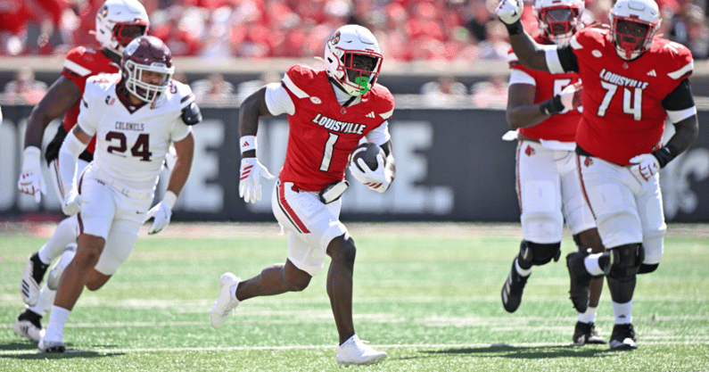 Aug 30, 2025; Louisville, Kentucky, USA; Louisville Cardinals running back Isaac Brown (1) runs the ball against Eastern Kentucky Colonels linebacker Kaden Smith (24) during the first half at L&N Federal Credit Union Stadium. Mandatory Credit: Jamie Rhodes-Imagn Images