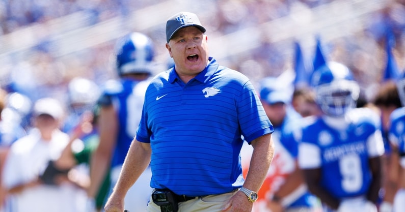 Aug 30, 2025; Lexington, Kentucky, USA; Kentucky Wildcats head coach Mark Stoops discusses a play with a referee during the first quarter against the Toledo Rockets at Kroger Field. Mandatory Credit: Jordan Prather-Imagn Images