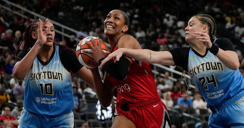 Las Vegas Aces center A'ja Wilson (22) drives the ball between Chicago Sky center Kamilla Cardoso (10) and guard Rachel Banham (24) during the second half of a WNBA basketball game at T-Mobile Arena. Mandatory Credit: Lucas Peltier-Imagn Images
