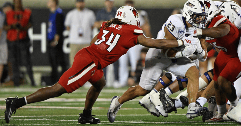 Sep 5, 2025; Louisville, Kentucky, USA; James Madison Dukes running back Jordan Fuller (23) runs the ball against Louisville Cardinals linebacker TJ Quinn (34) during the second half at L&N Federal Credit Union Stadium. Mandatory Credit: Jamie Rhodes-Imagn Images